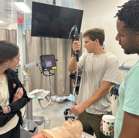 Three doctors practicing FOI in the Center for Patient Simulation.
